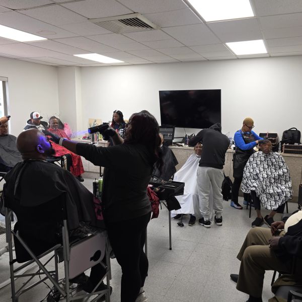 People getting haircuts in a barbershop.