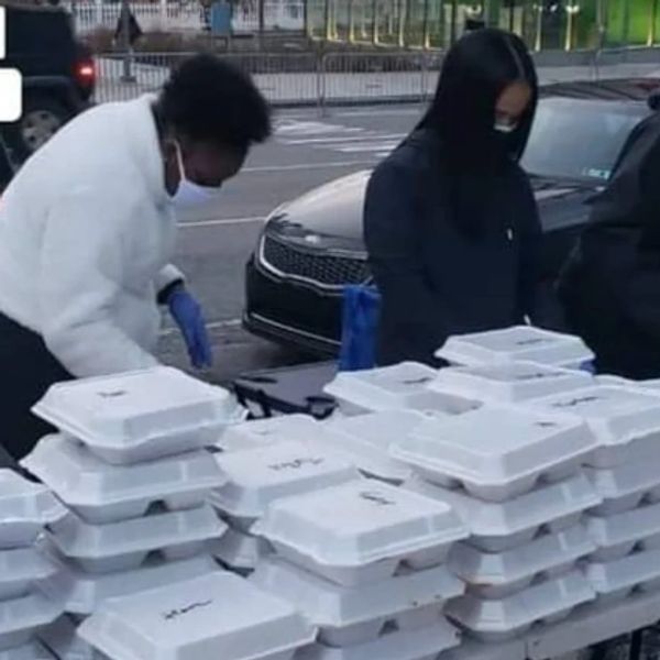 People organizing food containers outdoors.