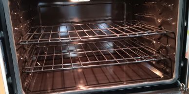 Horno eléctrico vacío con dos rejillas interiores.
