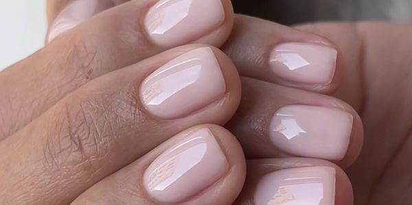 Close-up of neatly manicured nails with glossy, pale pink polish.