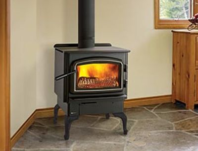 A black wood-burning stove with flames inside on a tiled floor.