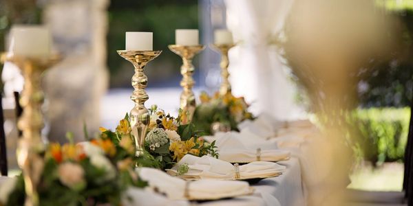 Elegant table setting with gold candle holders and floral arrangements.