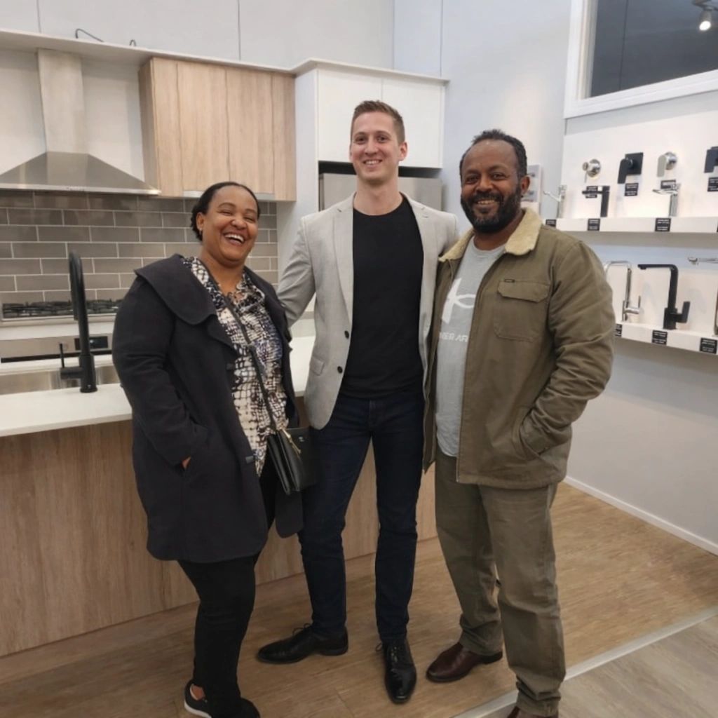 Building consultant Elliot Johnston with clients inside a modern display home kitchen