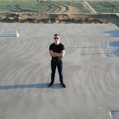 Man standing on concrete house slab at new home construction site