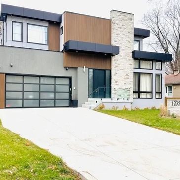 Modern two-story house with a sleek design and large windows.