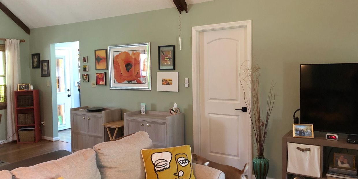 Cozy living room with green walls and modern decor.