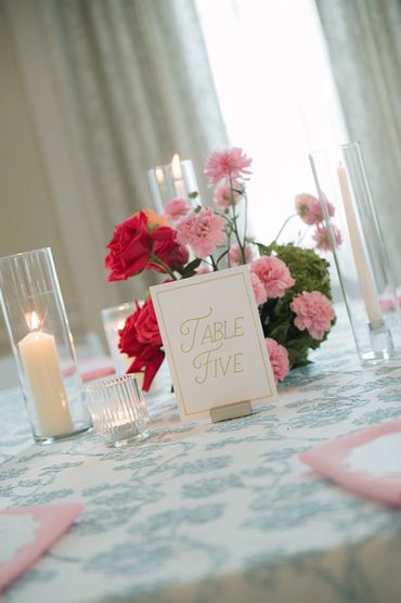 Elegant table setting with floral centerpiece and candles for Table Five.