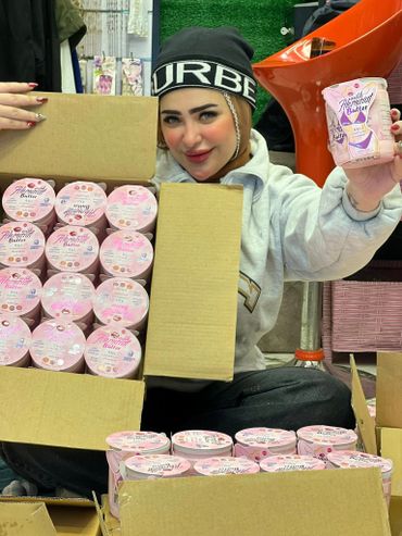 Woman showing multiple containers of Alemarat Butter from open boxes.
