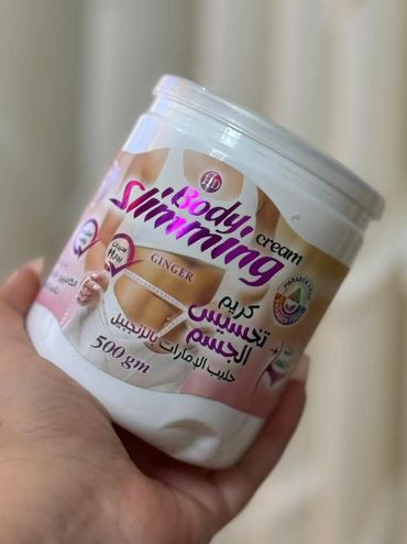 Hand holding a jar of body slimming cream with ginger.