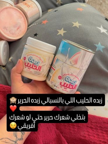 شخص يحمل عبوتين من زبدة الحليب مع تعليق باللغة العربية عن فوائدها.