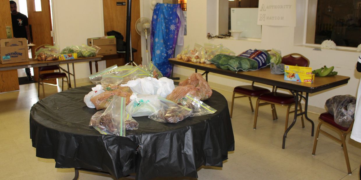 Tables with bags of food and supplies in a room.
