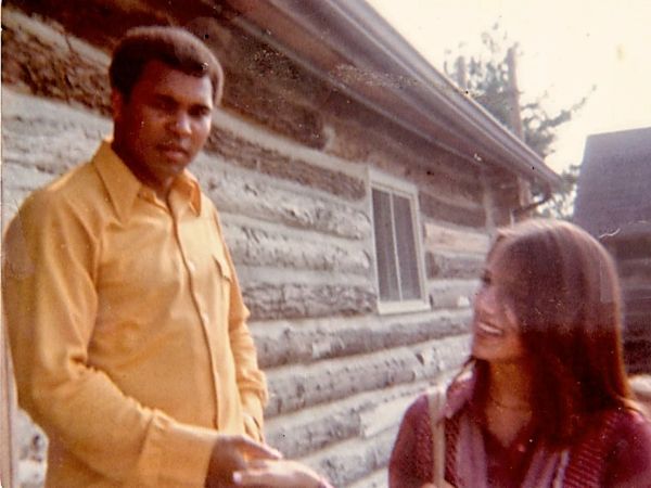 Man and woman sharing a moment outside a log cabin.