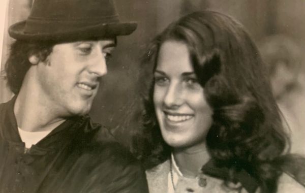 A man and woman smiling at each other in a vintage photo.
