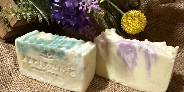Two artisanal soap bars with floral decorations on burlap.