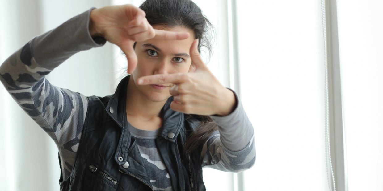 Woman framing her face with fingers.