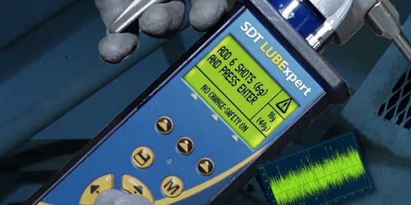 Close-up of an SDT LUBExpert tool with a waveform display.