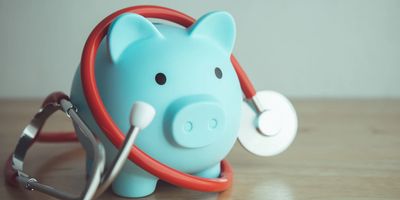 Blue piggy bank with red stethoscope wrapped around it.