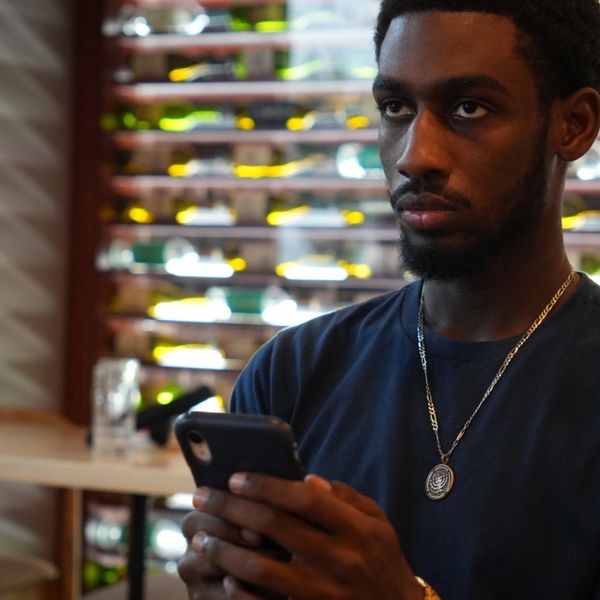 Man holding a phone, looking serious.