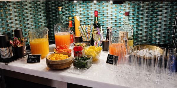 A vibrant mimosa bar with fresh fruit and drinks ready for guests.