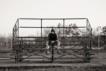 High School Grad Student, endurance athlete sitting on bleachers in Cold Lake Alberta.