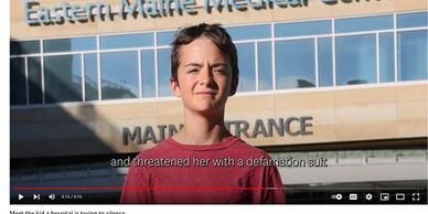 A young man stands confidently outside Eastern Maine Medical Center.