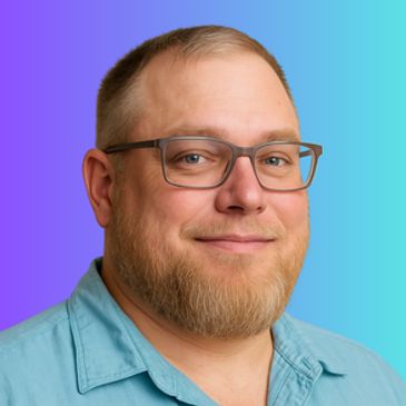 Portrait of a smiling man with glasses and beard.