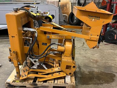 Industrial yellow hydraulic machine with hoses and metal parts on a pallet.
