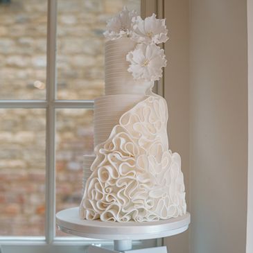 White three tiered cake with white sugar flowers
