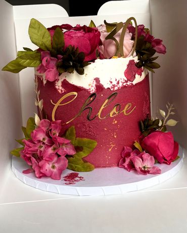Elegant pink and white floral cake with gold 'Chloe' and number 70 topper.