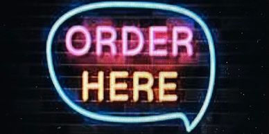 Neon sign glowing with the words ORDER HERE in pink and yellow.