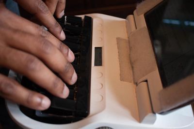 An up-close shot of fingers on a stenography keyboard that has black keys and a white plastic frame