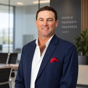 Man in a suit smiling indoors.