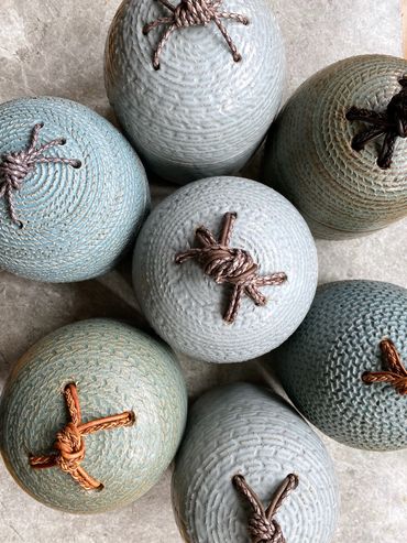 carved stoneware jars with leather knots