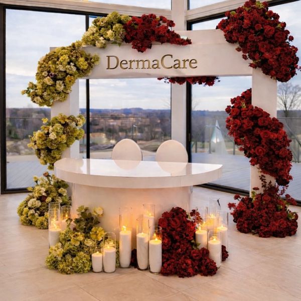 Elegant DermaCare booth decorated with red and yellow flowers and candles.