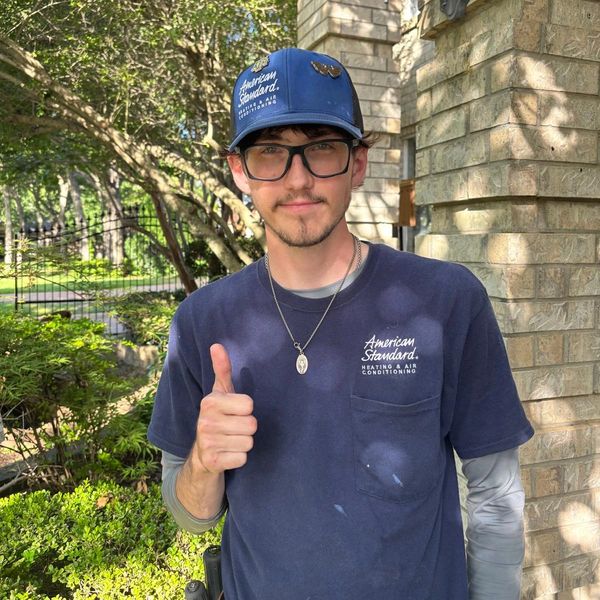 Young man giving thumbs up outdoors.