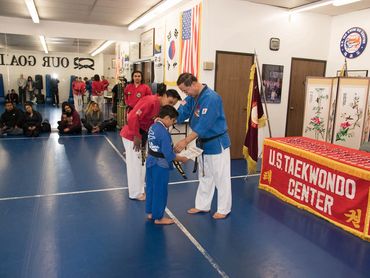Man presenting award to a child.