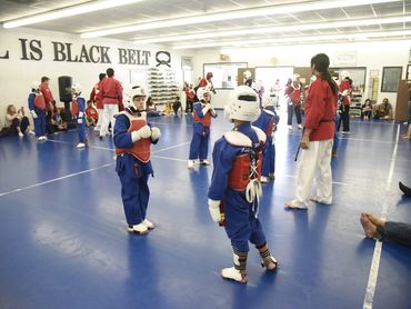 Kids in protective gear practicing martial arts.