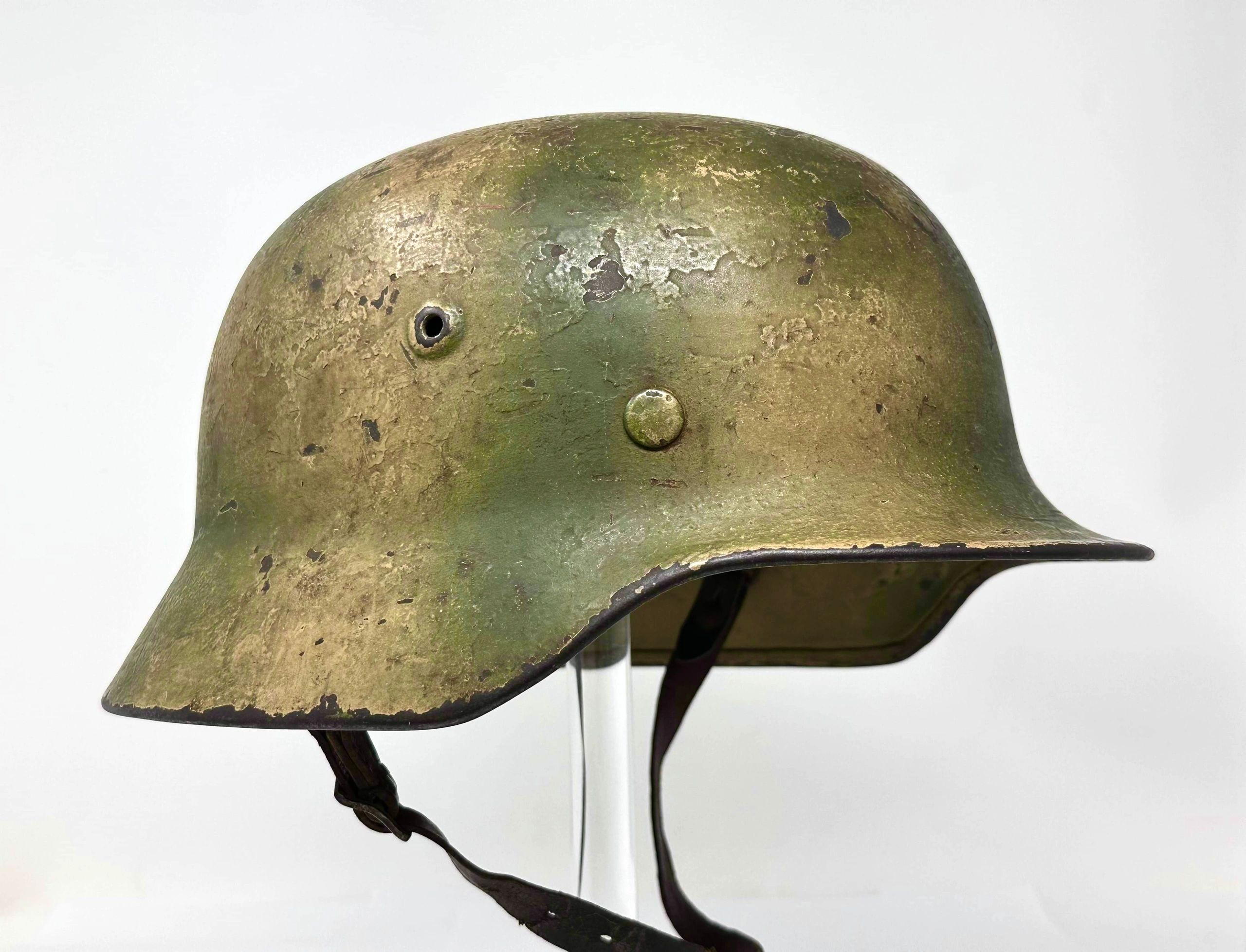 Worn military helmet with green and brown patina.