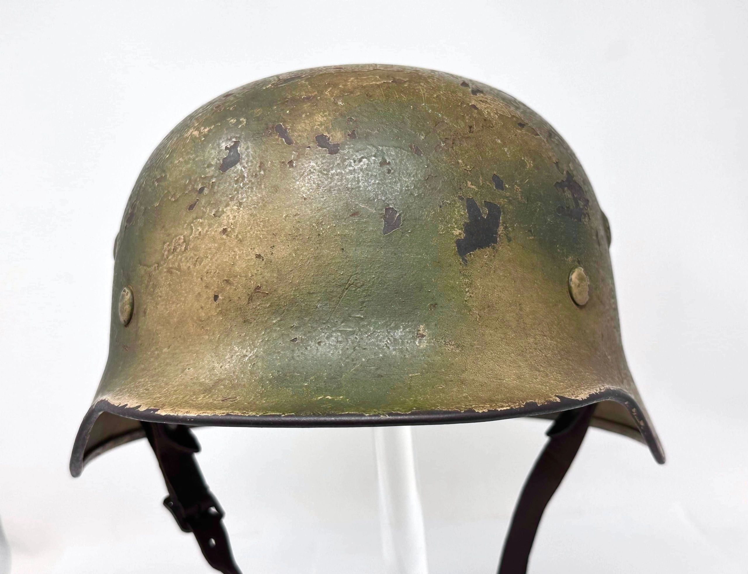 Worn military helmet with chipped paint.