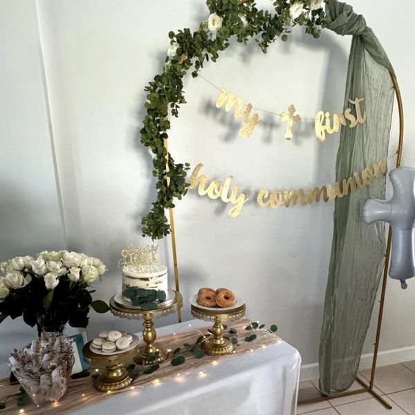 Elegant first holy communion dessert table with floral and gold accents.