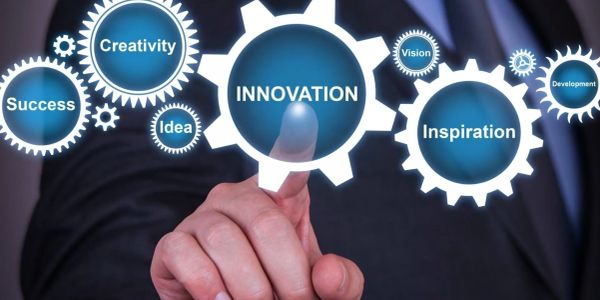 Finger touching digital gear labeled Innovation surrounded by creativity and inspiration.