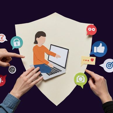 Hands interacting with digital icons around a paper cutout of a person on a laptop.