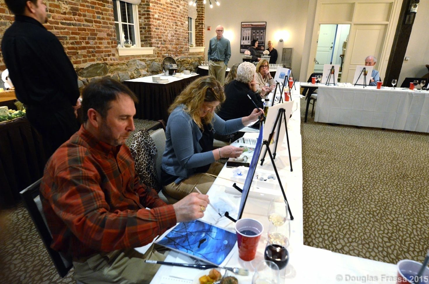 group of people painting canvases together