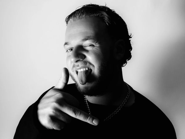 Man making a playful face sticking out tongue with hand gesture.