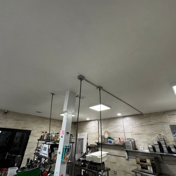 Commercial kitchen with cooking equipment and shelves.