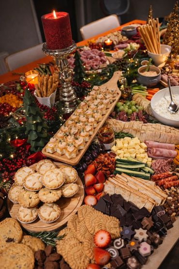 Festive holiday spread with appetizers, desserts, and decorations on a table.
