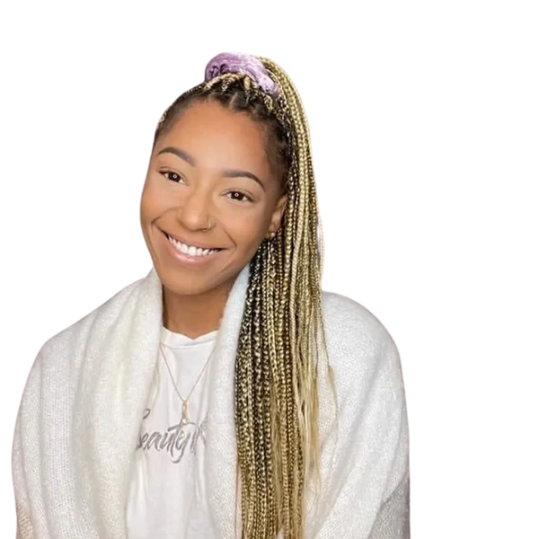 Smiling young woman with long braided hair and a cozy white shawl.