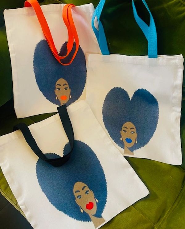 Three white tote bags with heart-shaped afro woman designs and colorful handles.