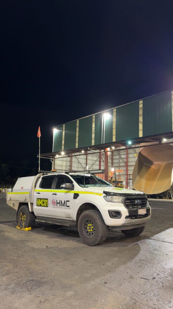White utility truck parked at night near an industrial building.