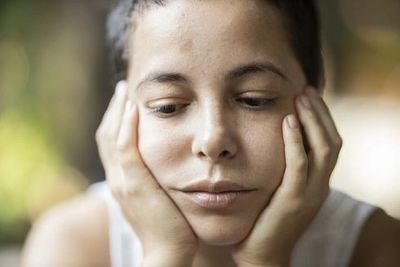 A person pondering the status of her relationship, reflecting thoughtfully on her connection and fut